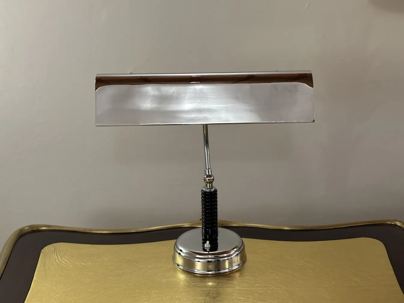 Antique table lamp with a round base and elongated shade in a cozy setting.