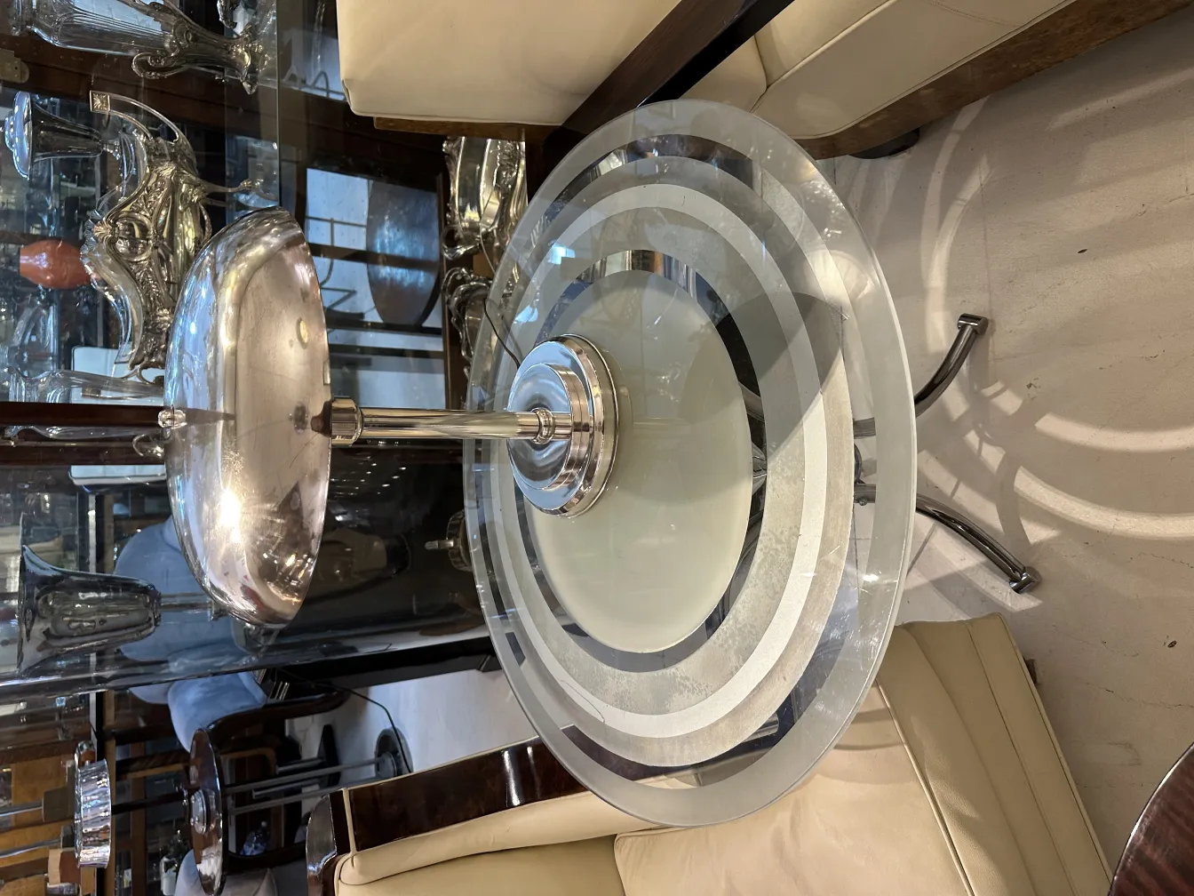 Antique table lamp with silver base and round shade, elegant atmosphere.