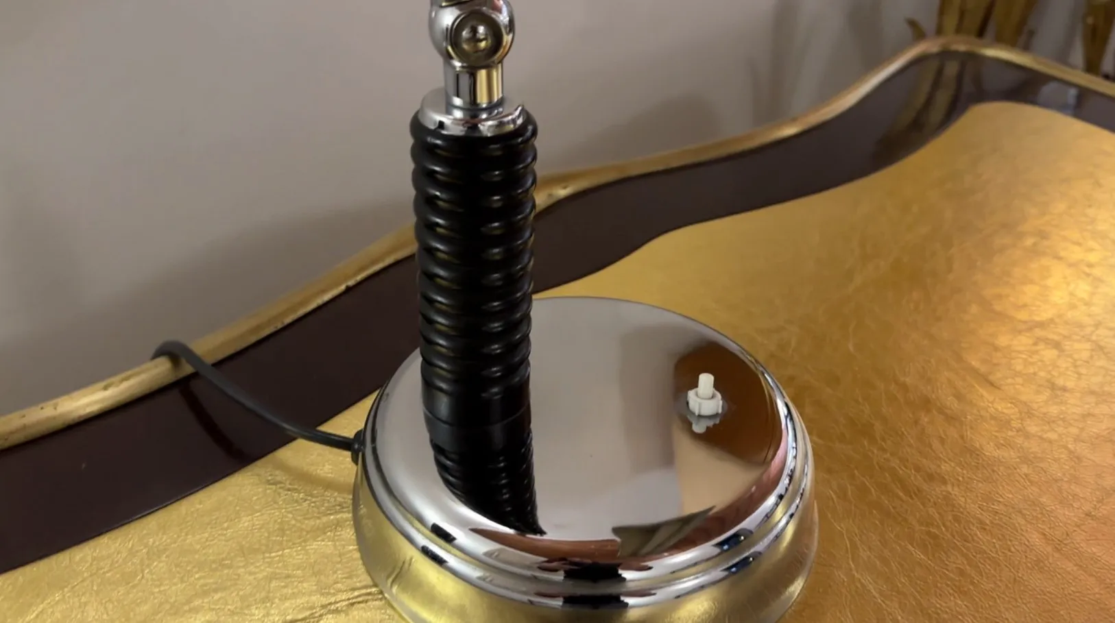 Luminária de mesa antiga com uma base brilhante e elegante, perfeita para qualquer ambiente.