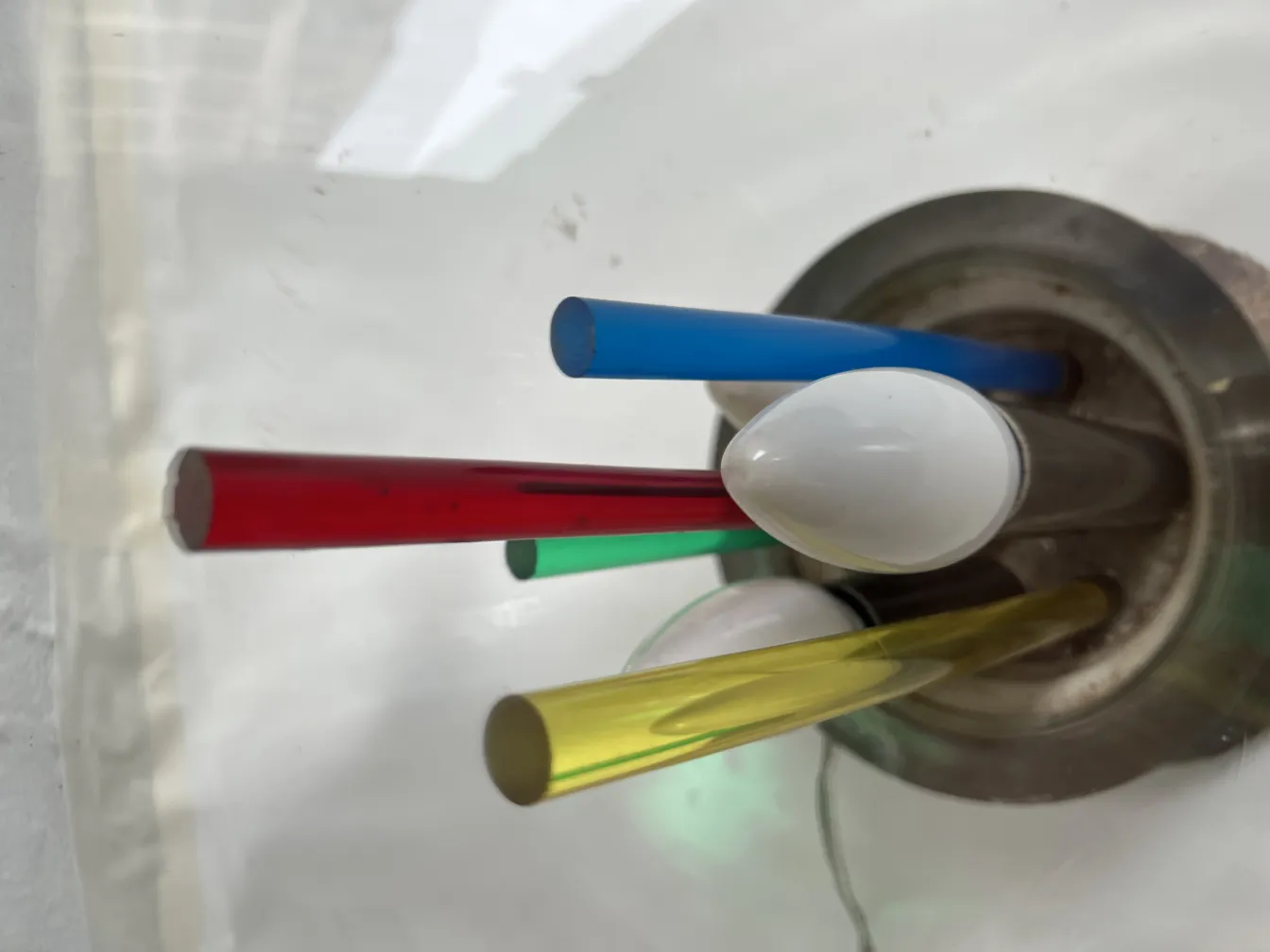 antike tischlampe mit verschiedenen bunten stangen am fuß