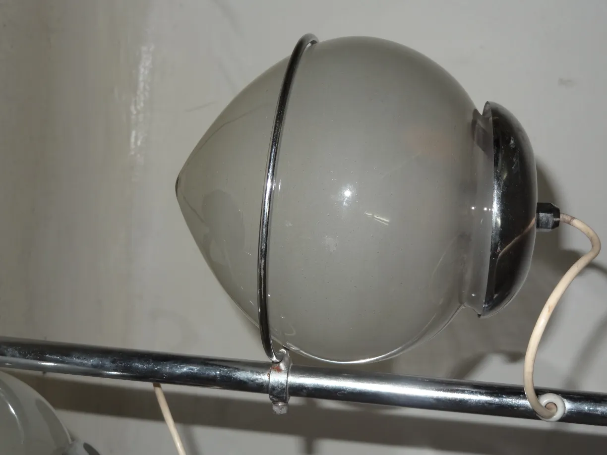 Antike Tischlampe mit sphärischem Design und klassischem Stil, vor neutralem Hintergrund.