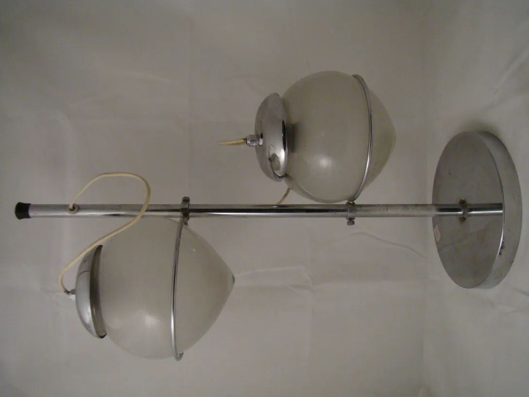 Antike Tischlampe mit zwei Lichtkugeln auf einem Stand, in einer neutralen Umgebung.