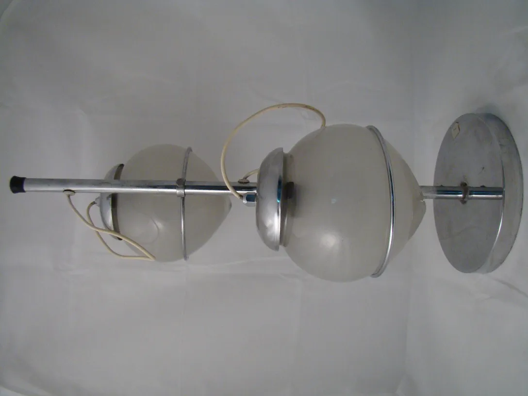 Lampe de bureau ancienne avec lumière douce et sphère opaline dans un cadre minimaliste.