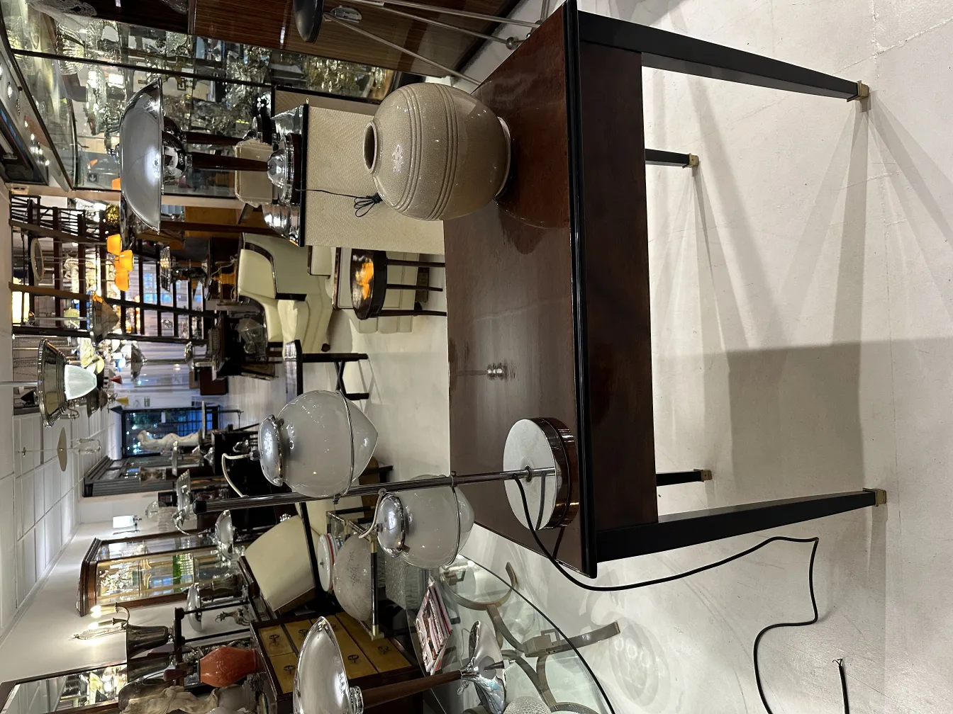 Lampada da tavolo antica con base lucida e dettagli chiari in un ambiente elegante.