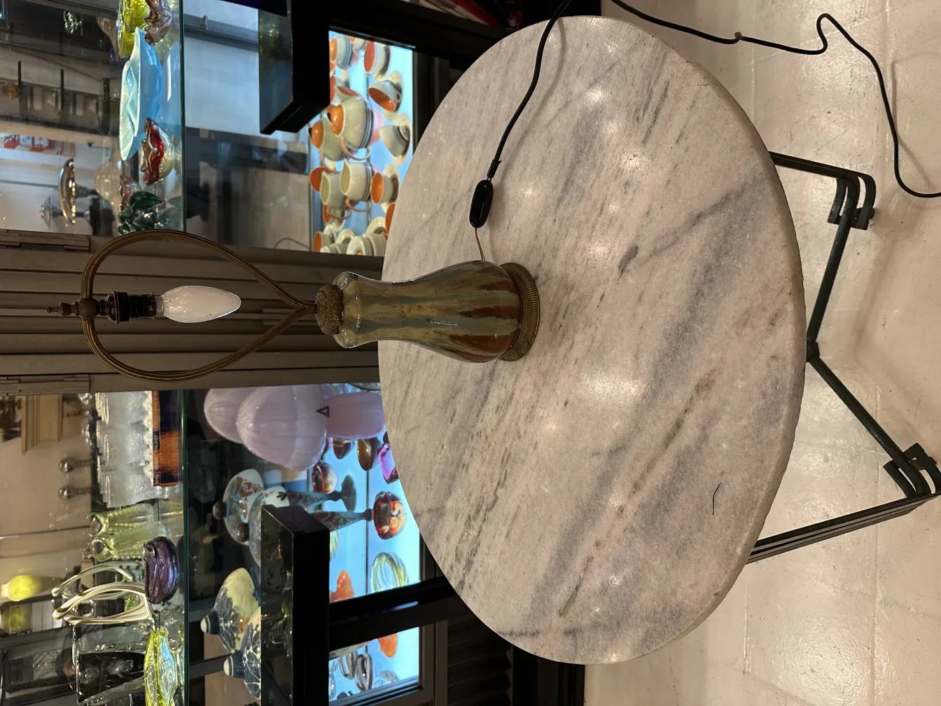 Lámpara de mesa antigua con base de vidrio, ambiente elegante.