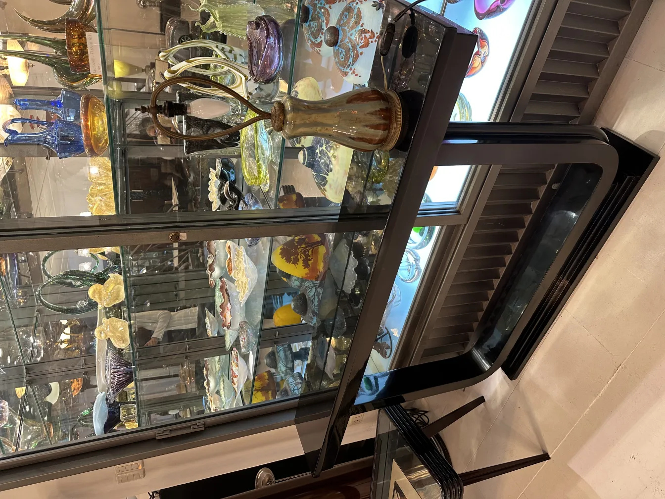 Antike Tischlampe dekorativ mit klassischem Design in eleganter Umgebung, umgeben von Glasartefakten.