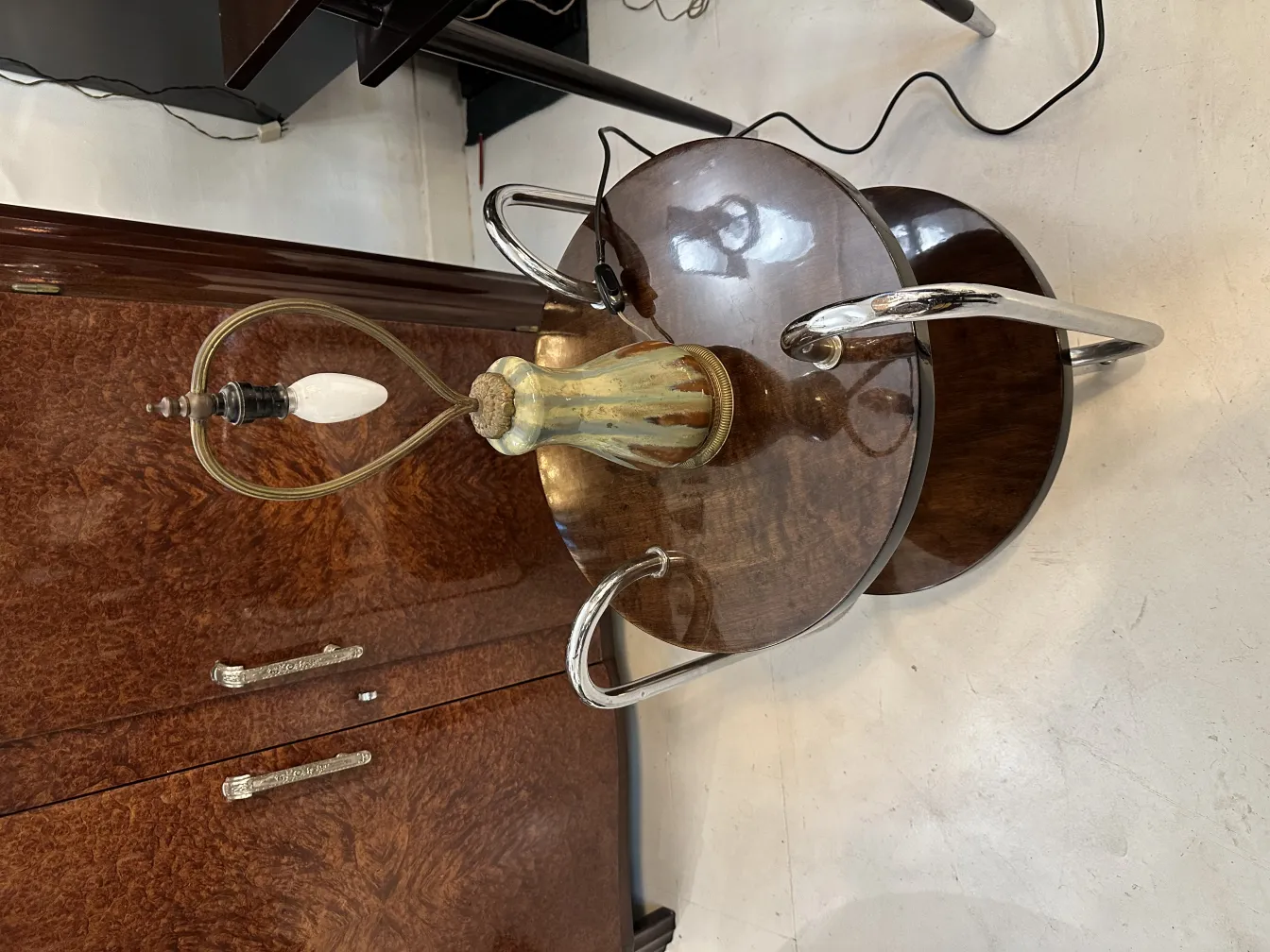 Lampe de bureau ancienne avec une base décorative et un dessus en verre, dans un environnement élégant.