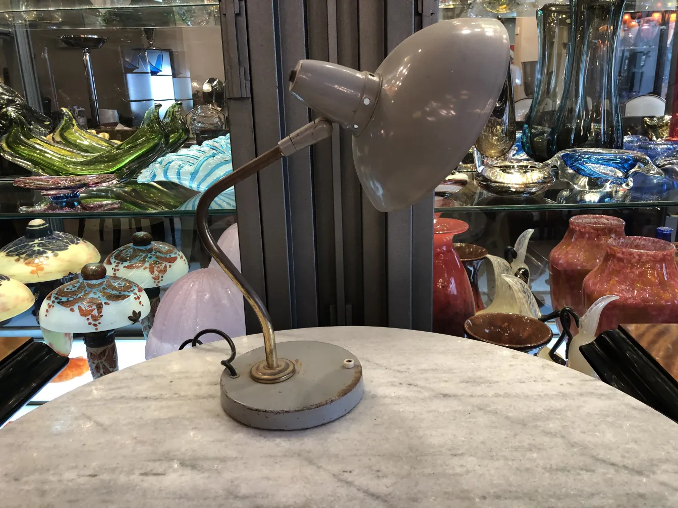 Antique table lamp with round base, decorative, in a setting filled with antiques