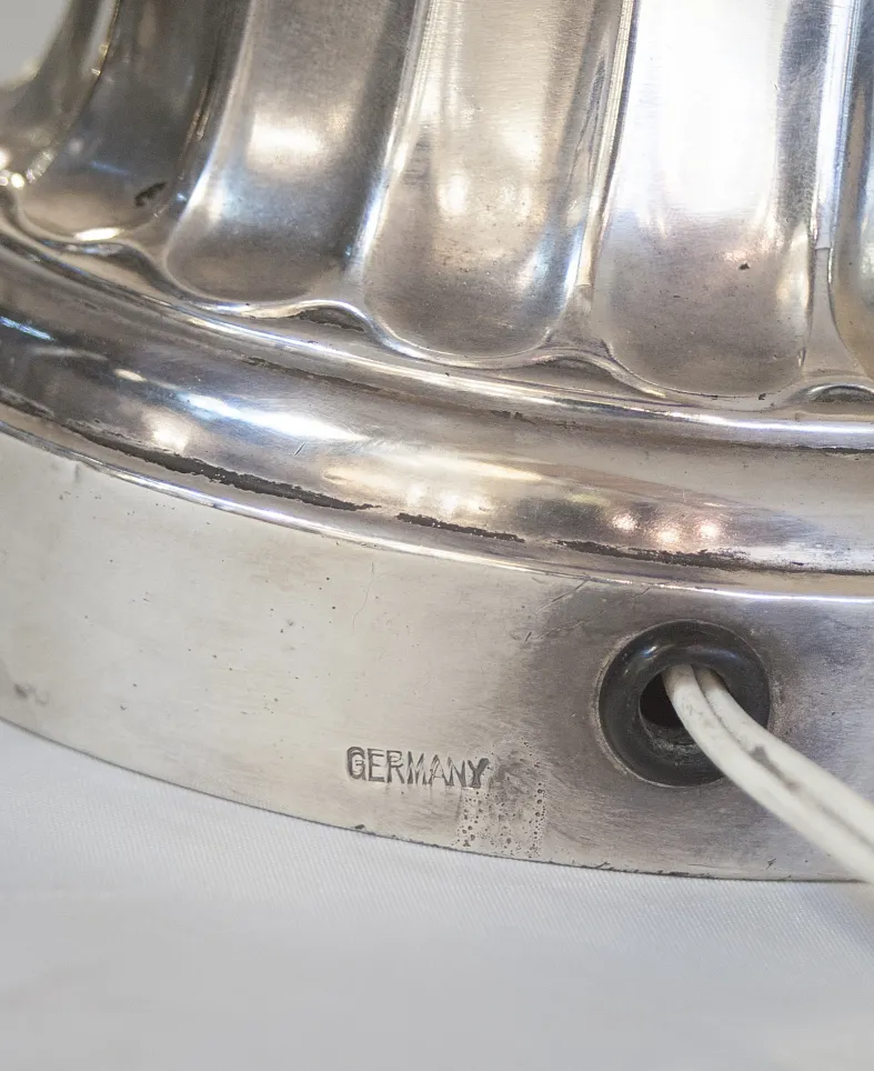 detail einer antiken tischlampe charles schneider mit silberner basis und sichtbarem kabel