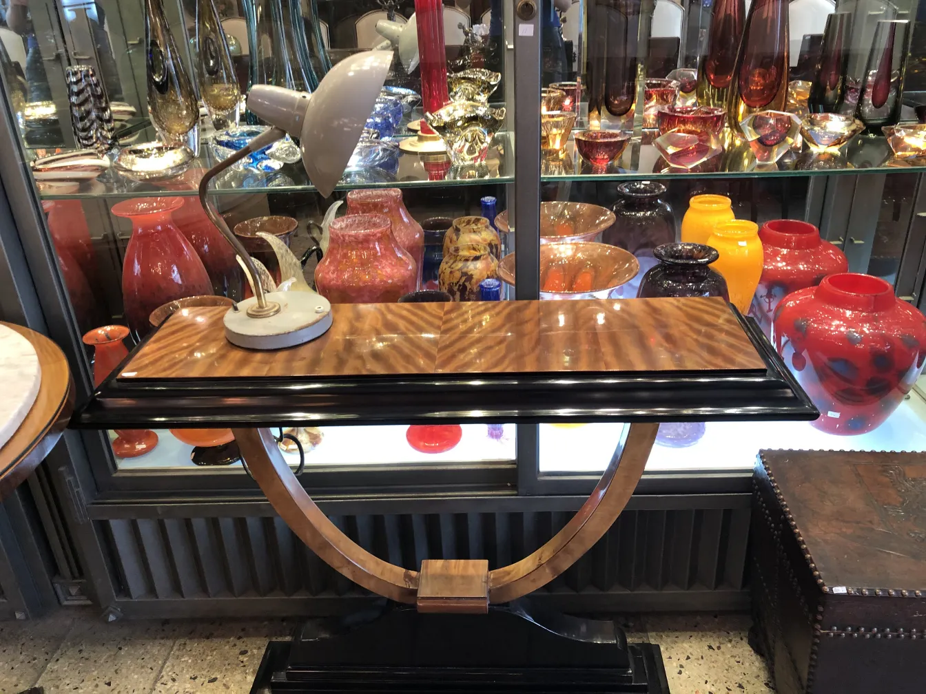 Lámpara de mesa antigua en un entorno elegante con jarrones de colores variados