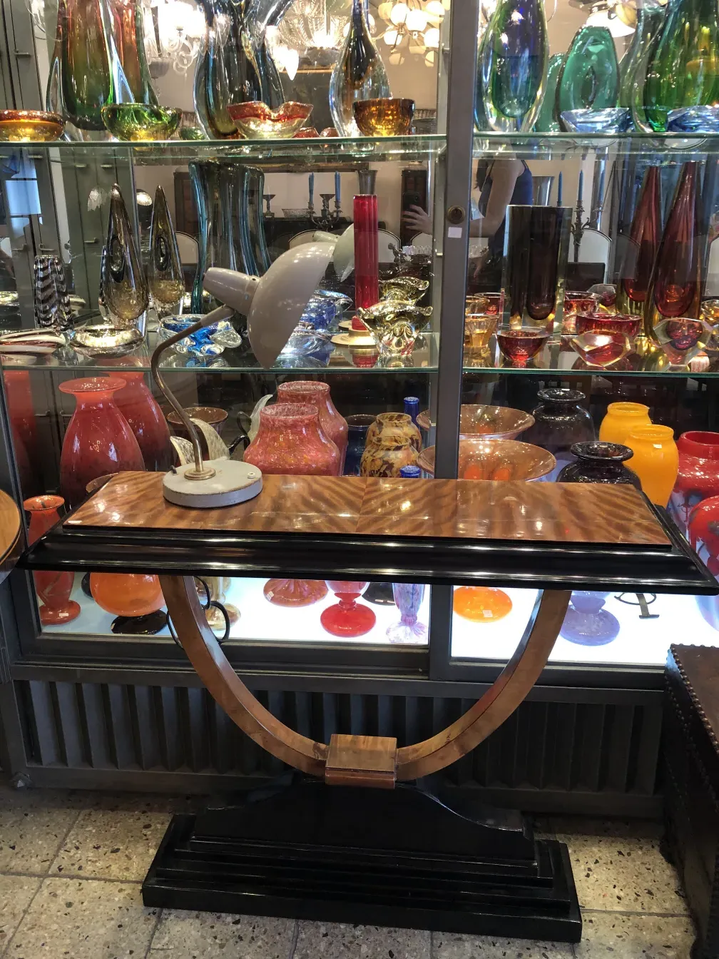 Lámpara de mesa antigua de Serge Mouille en un ambiente con cristales coloridos