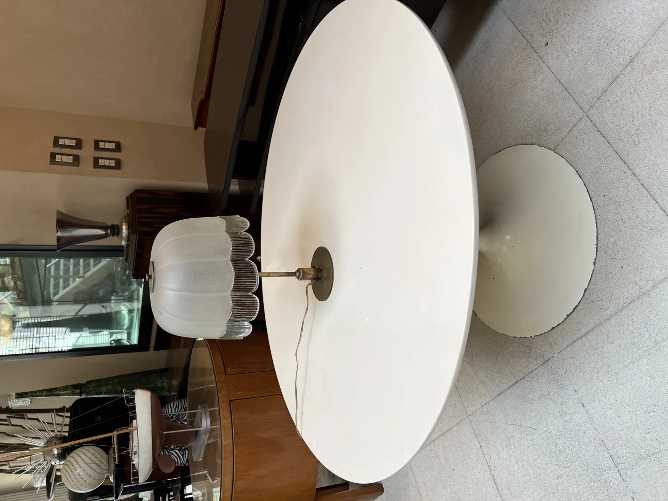 Lámpara de mesa antigua con pantalla blanca en un entorno moderno. Fondo de mueble contemporáneo.