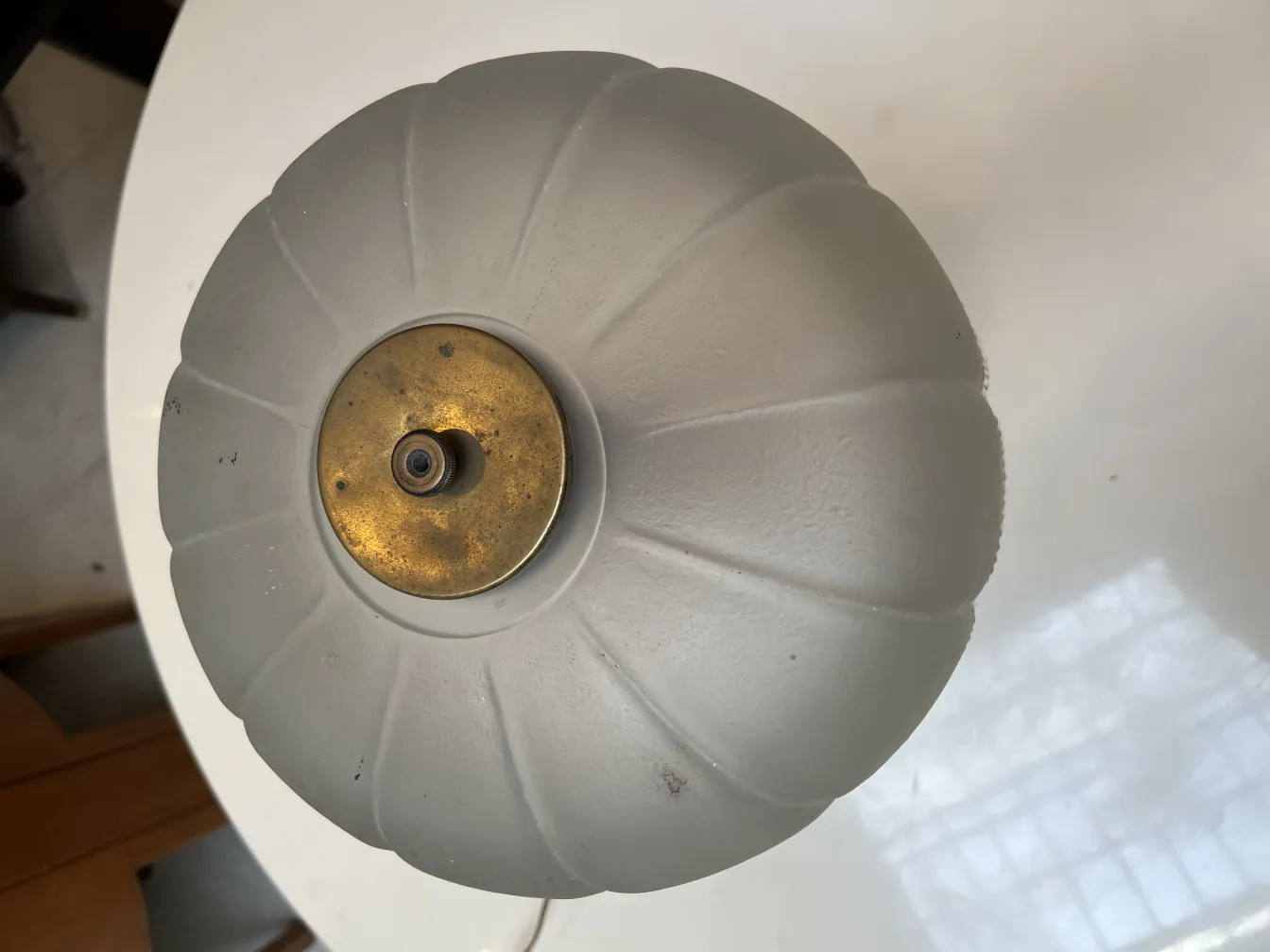 Lámpara de mesa antigua con sombra redondeada y base dorada, en un ambiente acogedor.