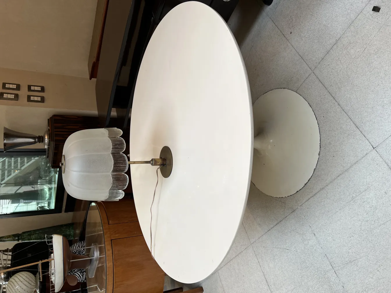 Luminária de mesa antiga com cúpula branca e base redonda, em um ambiente elegante.