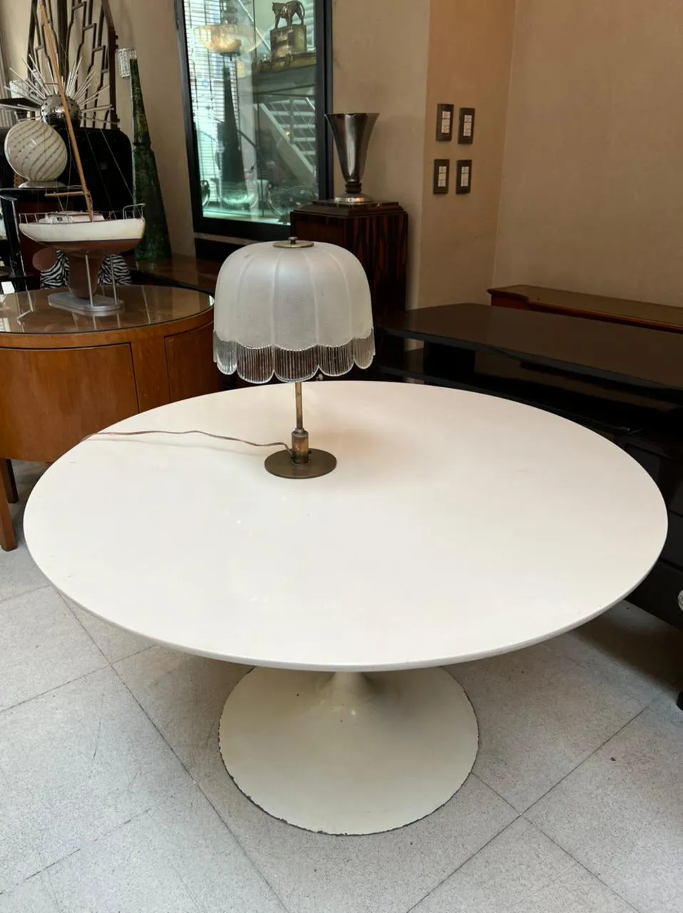 lampada da tavolo antica con paralume bianco su tavolo rotondo bianco, illuminazione soft in un ambiente antico