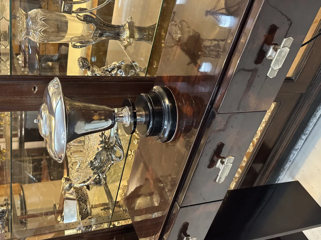 Lampada da tavolo antica con design lucido ed elegante, circondata da altri oggetti decorativi.