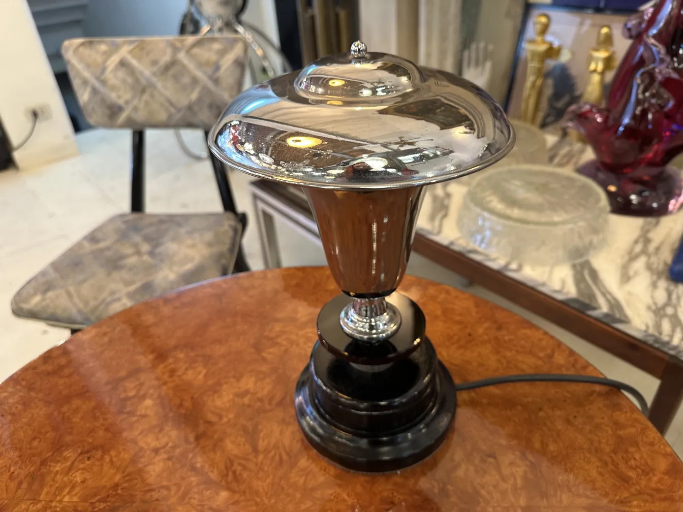 lampara de mesa antigua con base negra y pantalla brillante, en un ambiente elegante