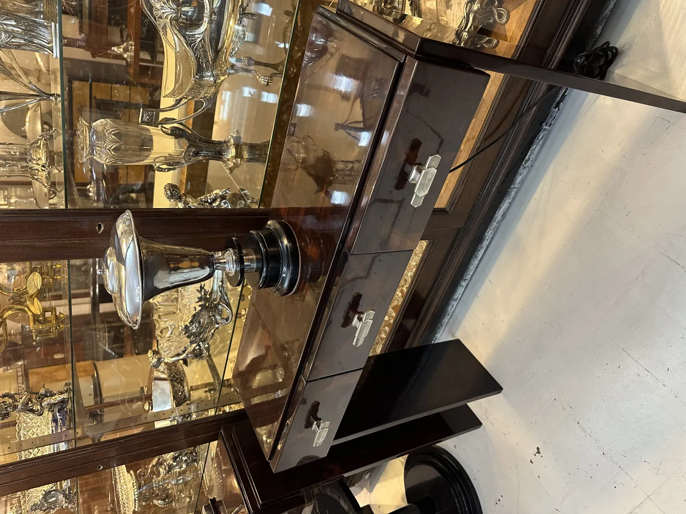 антикварная настольная лампа с элегантным дизайном, окруженная различными антиквариатами