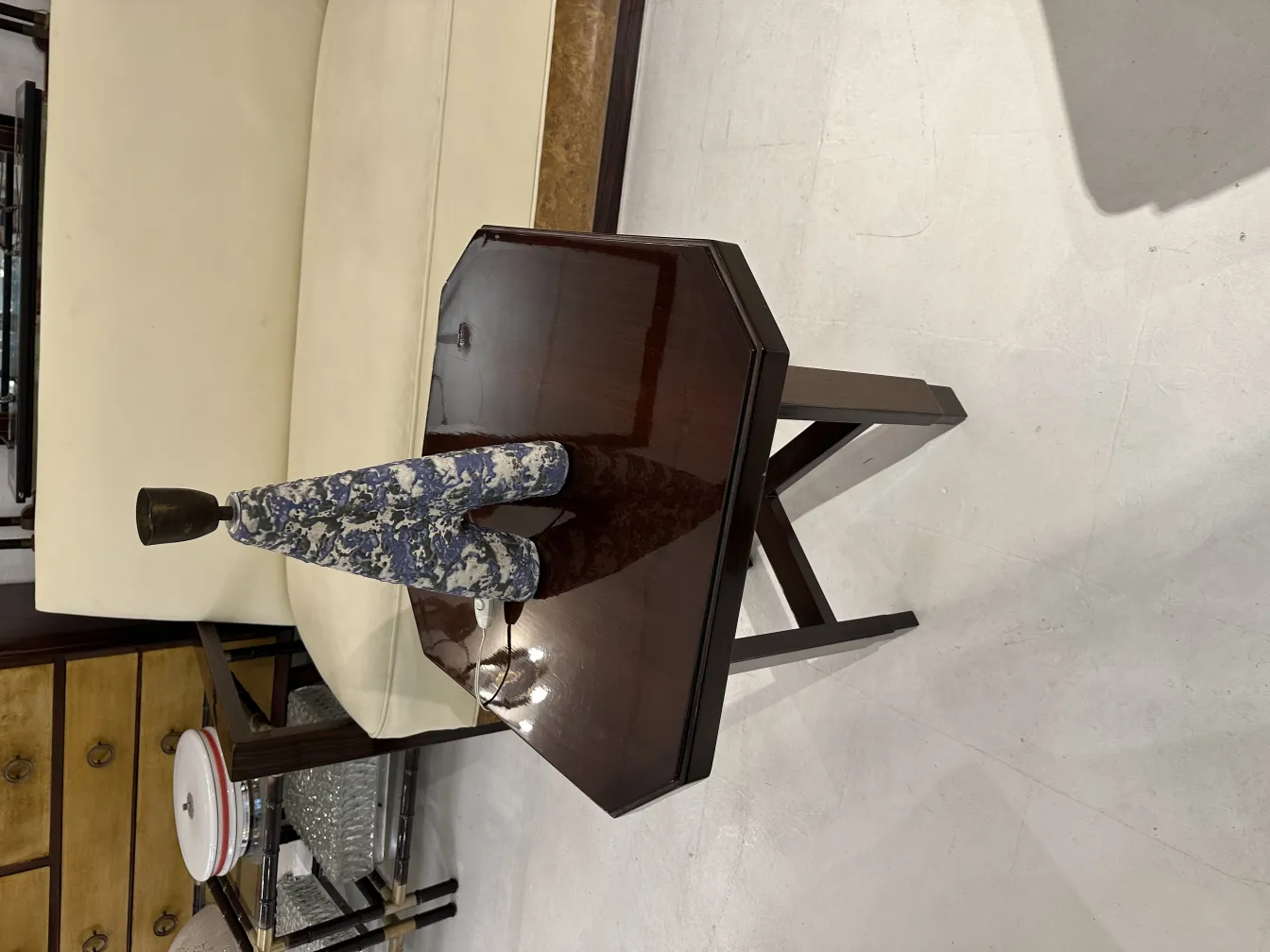 antique table lamp with decorative base and colorful design, beside a light-colored sofa