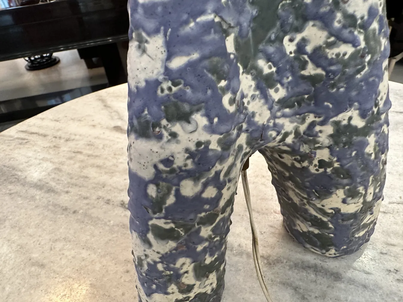 Antike Tischlampe mit buntem Design und einzigartigen Formen, die eine gemütliche Atmosphäre im Raum schafft.