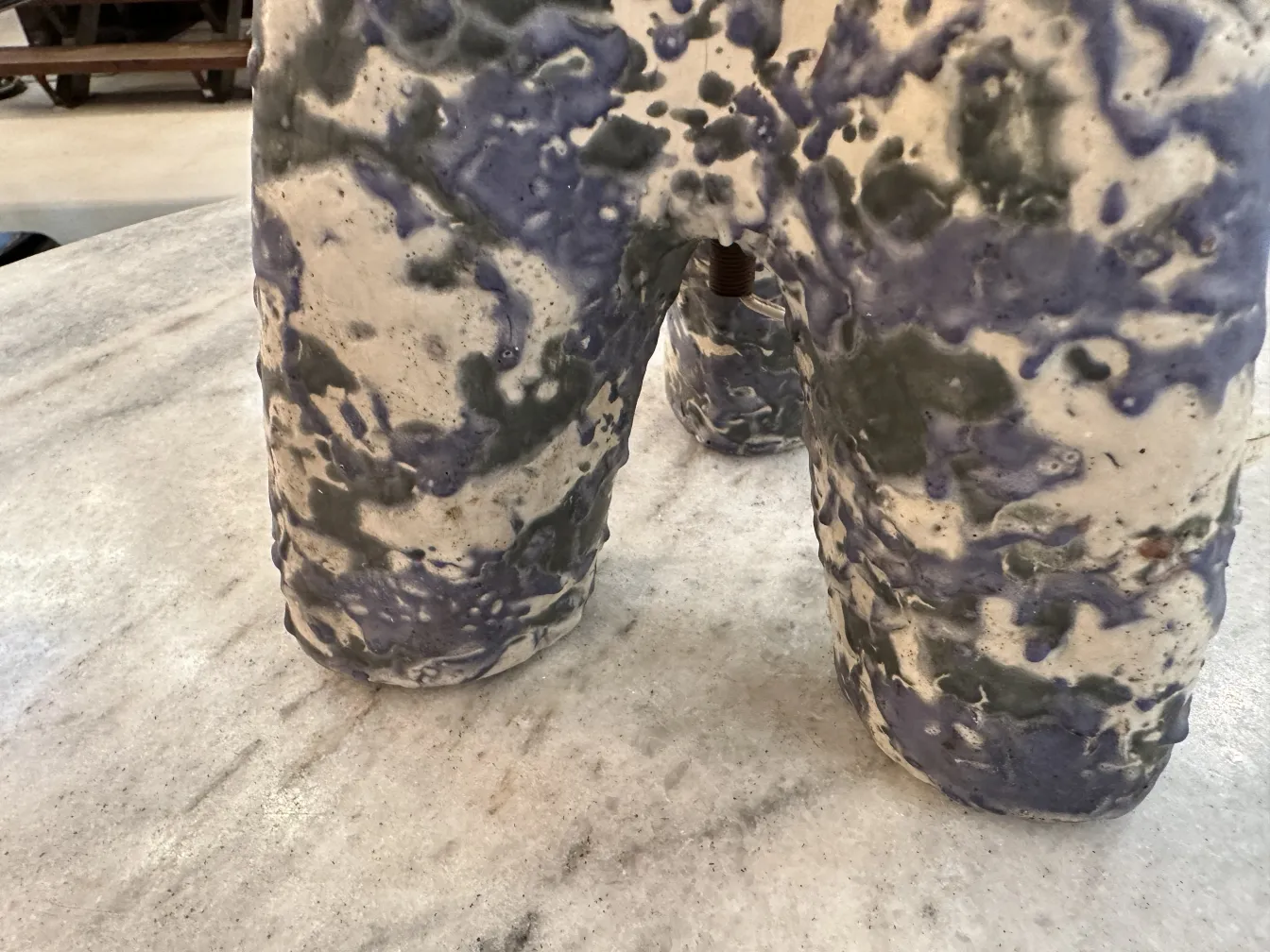 luminária de mesa antiga com formas irregulares e cores suaves em uma mesa de mármore