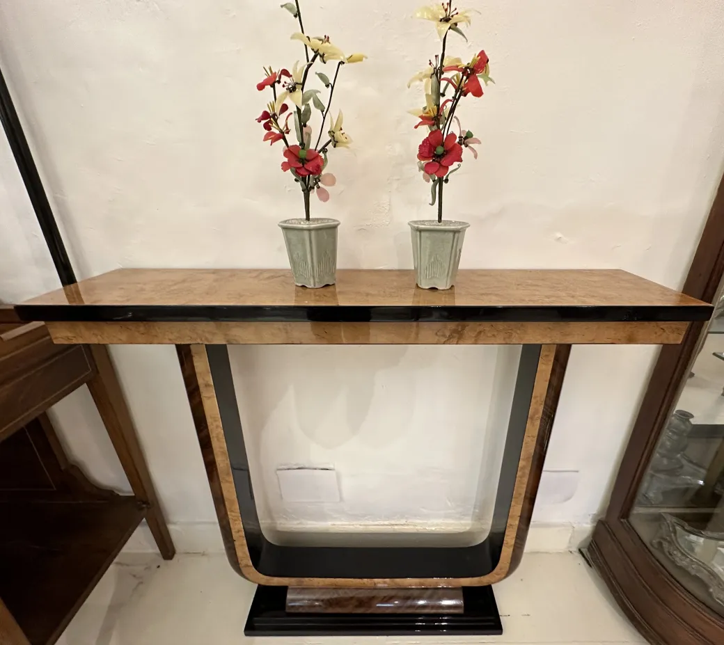 Antiga consola com decoração floral e base elegante.