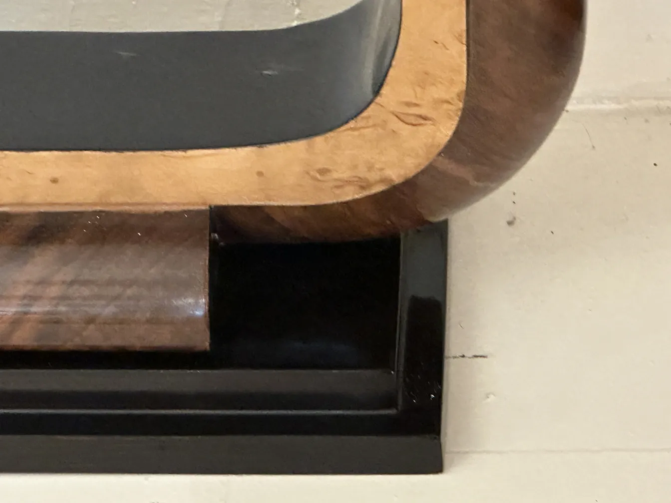 antica console decorativa con design curvo e base nera