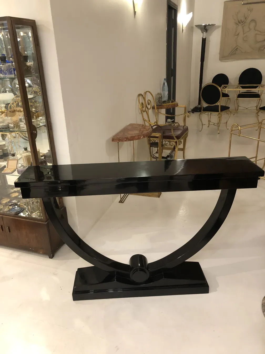 antique black console table with curved base and light background