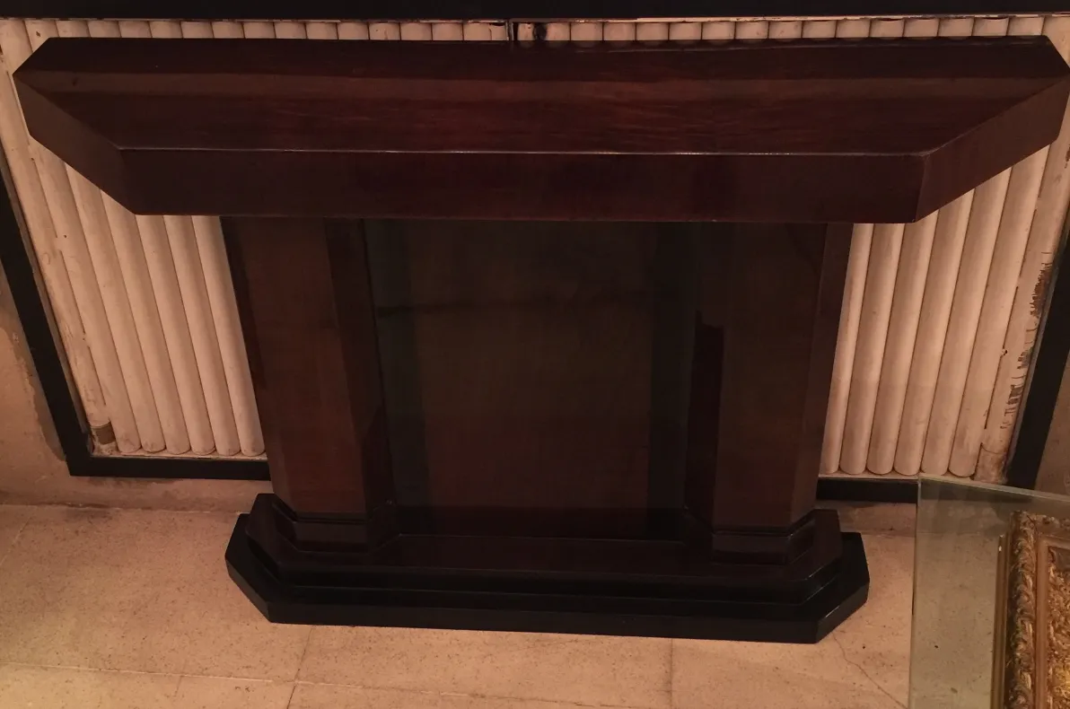 Antigua consola con forma rectangular y base amplia.