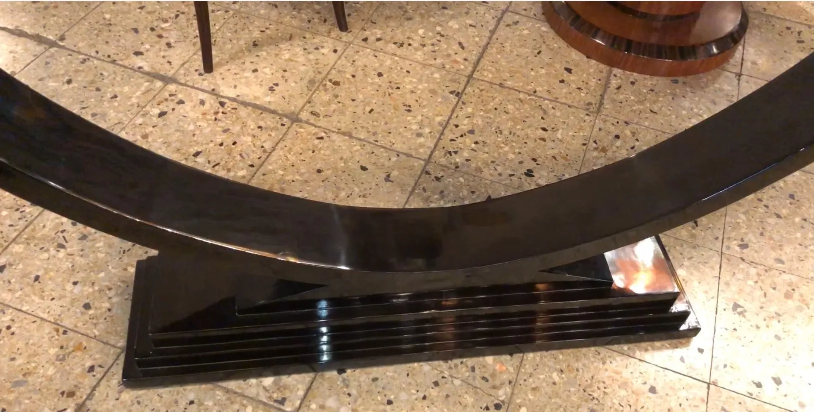 장식적인 돌 바닥 위에 있는 오래된 검은색 콘솔 테이블