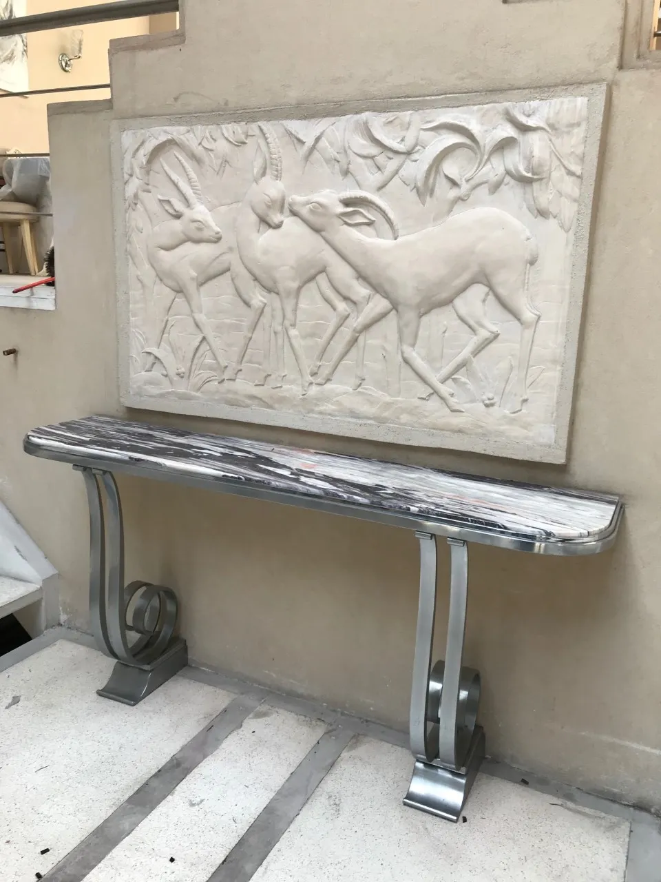 Antique console table with intricate design and background art