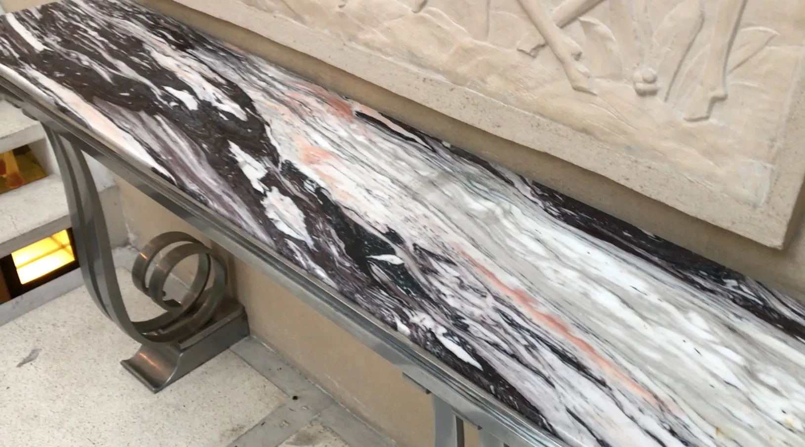 प्राचीन कंसोल टेबल Montagnac Pierre का दृश्य, जिसमें एक सजावटी दीवार के खिलाफ एक सुरुचिपूर्ण डिजाइन है。