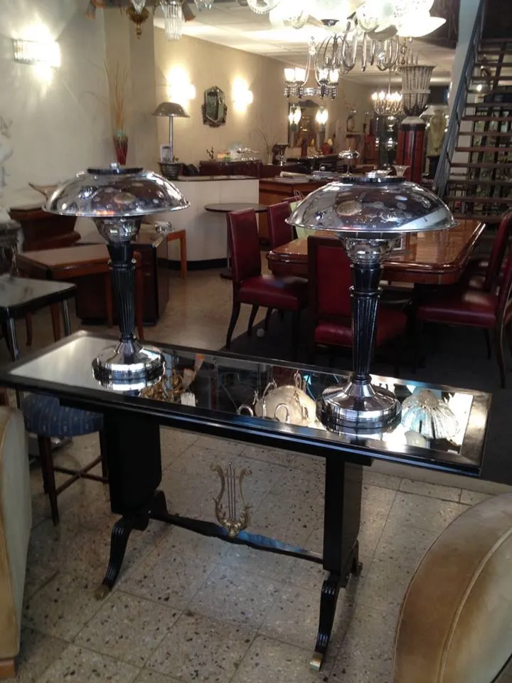 antica console con superficie riflettente e lampade