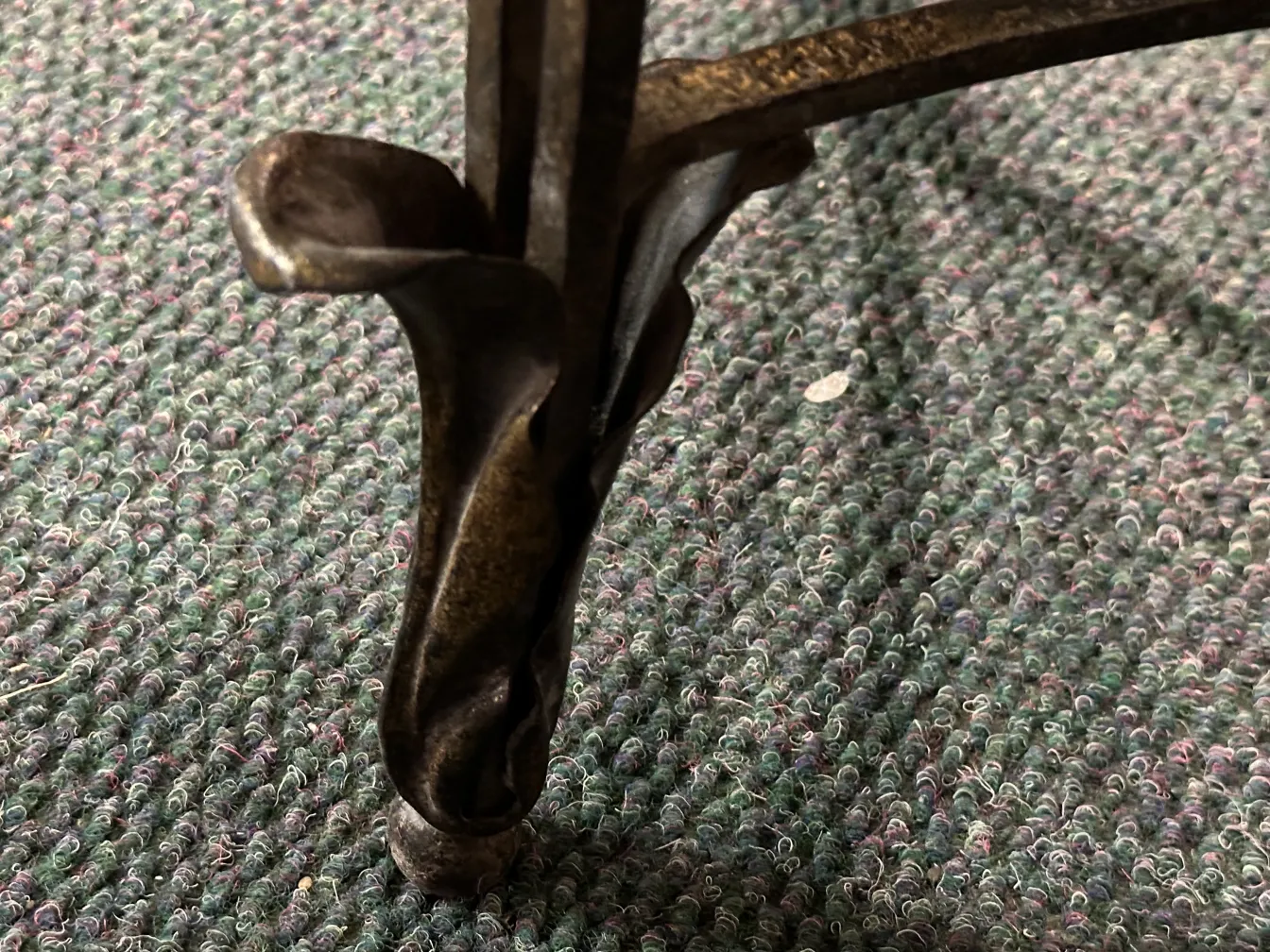 detalhe da base de uma console decorativa antiga, fundo têxtil