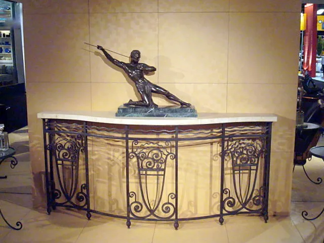 antique console with decorative design and statue