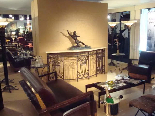 Consola antigua decorada con figura, ambiente elegante.