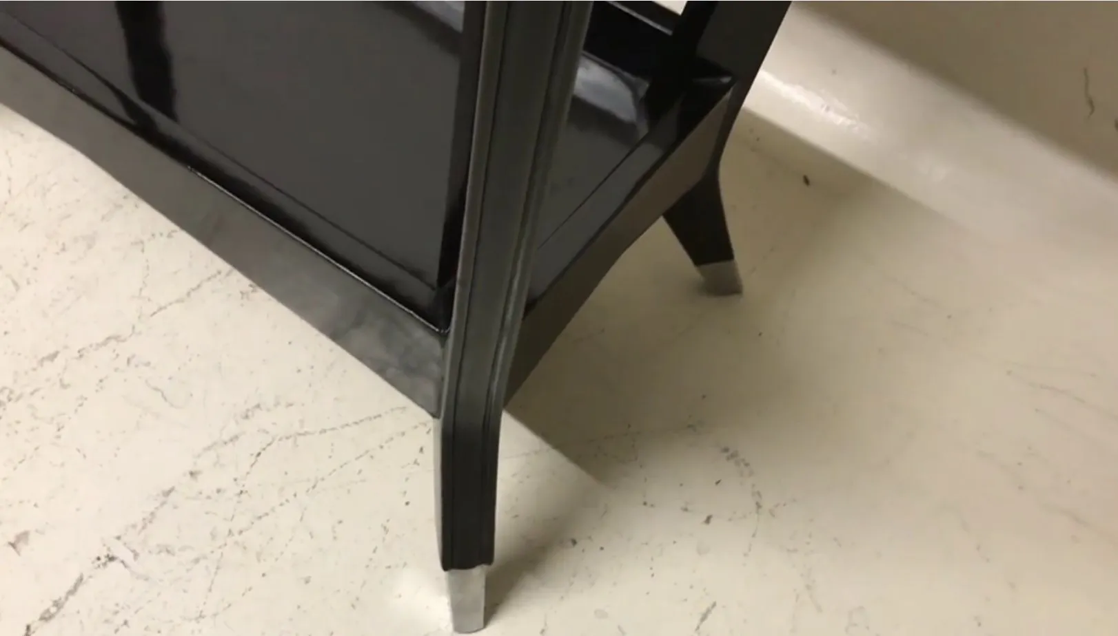 consola antigua de color negro con patas elegantes y modernas