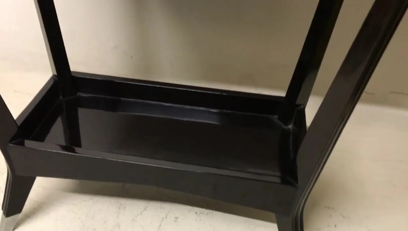 schwarze antike Konsole mit eleganten Formen auf hellem Hintergrund