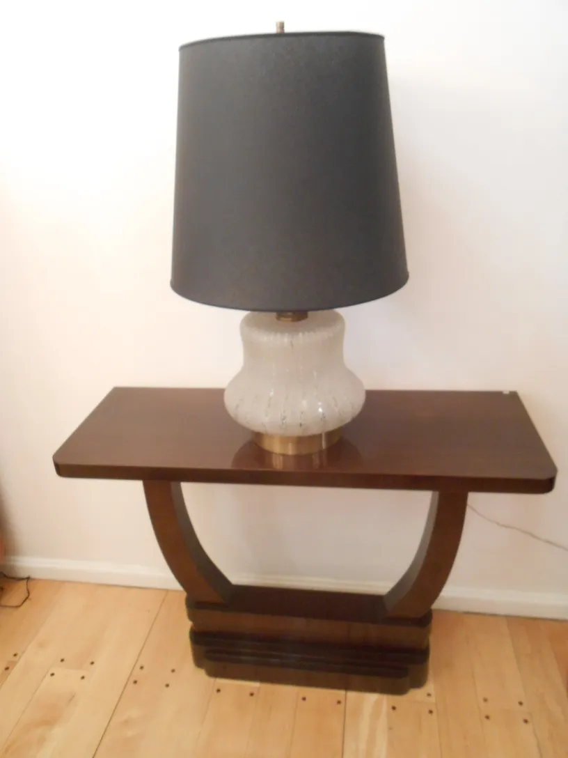 Antike Konsole mit einer schwarzen Schirmlampe oben