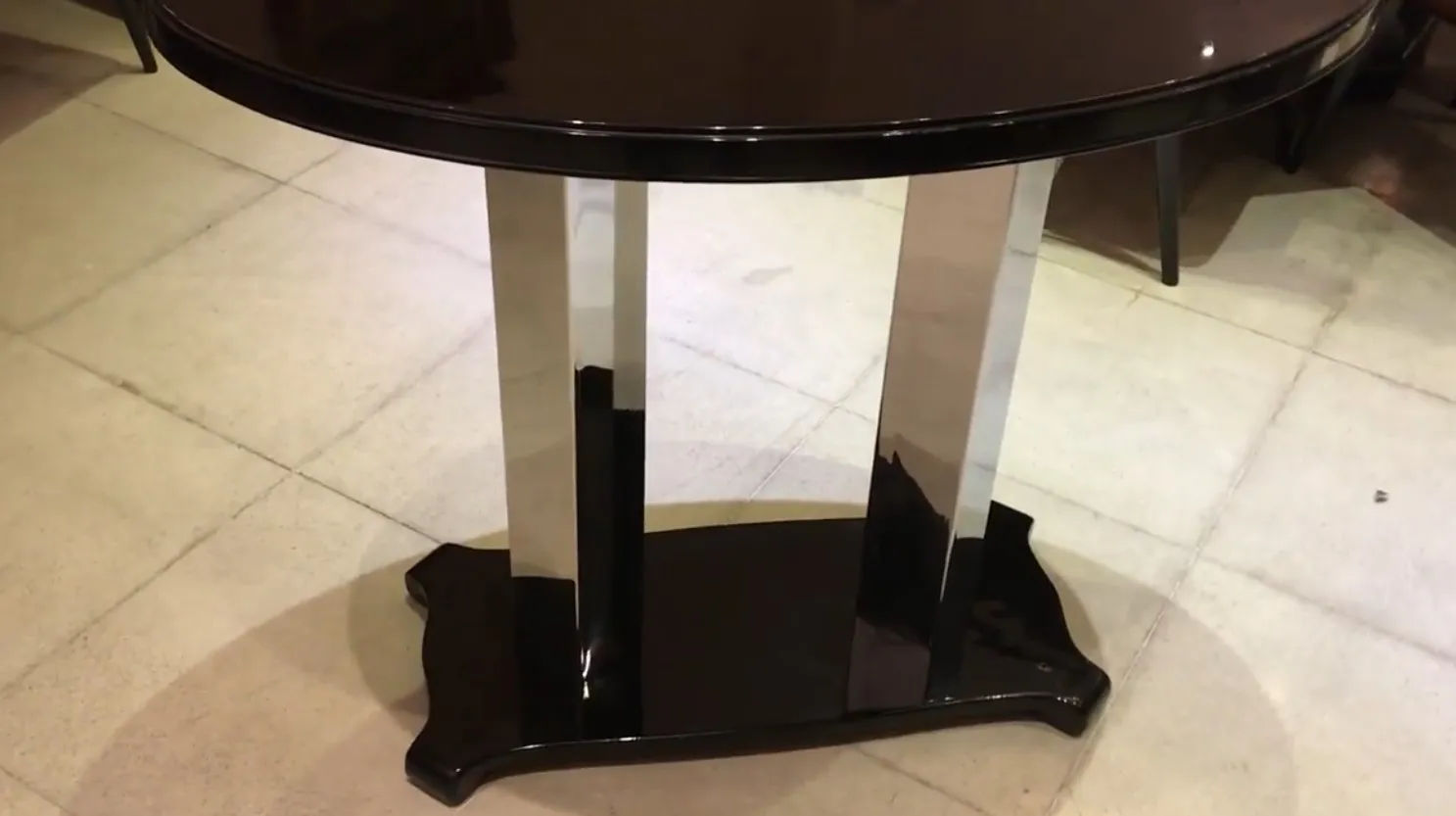 consola redonda antigua con base negra y cromada, elegante diseño