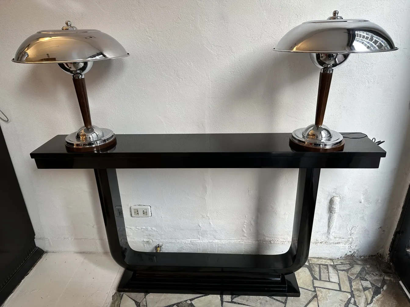 deux consoles antiques avec des détails en métal brillant et des lampes