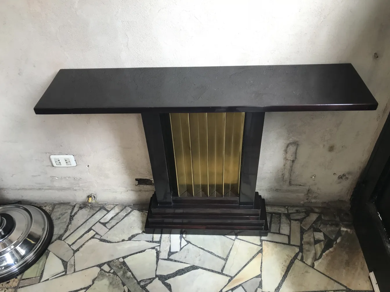 zwei antike Konsolen mit elegantem Design, vor einer Wand