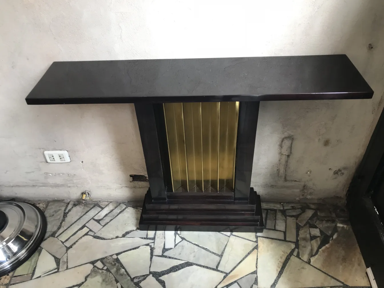 consolas antiguas con superficie negra y pie dorado en un ambiente sencillo