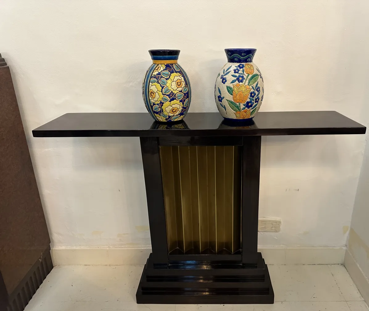 Deux consoles anciennes avec des fleurs décoratives et des vases
