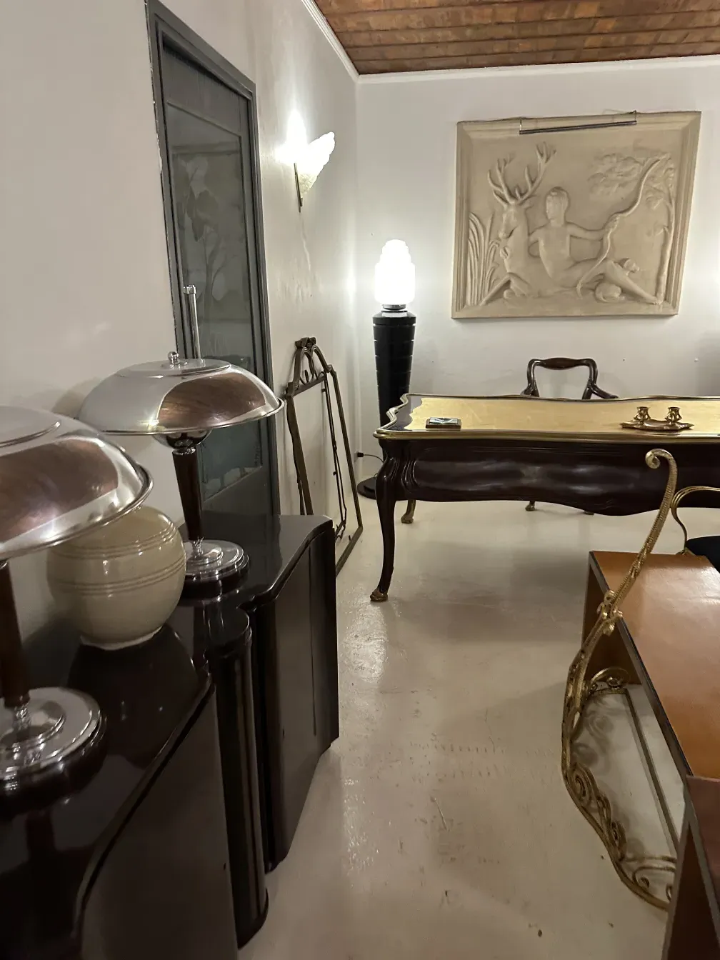 View of 2 antique consoles in a room with elegant decor.