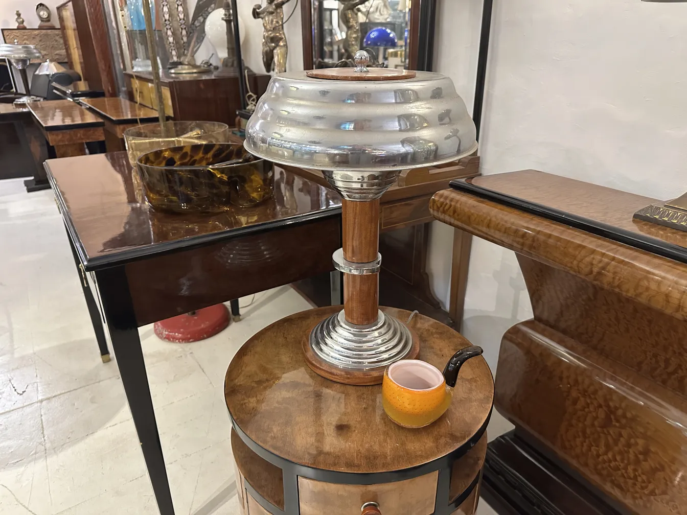 duas consoles antigas com bases circulares e detalhes dourados, em um ambiente de antiguidades