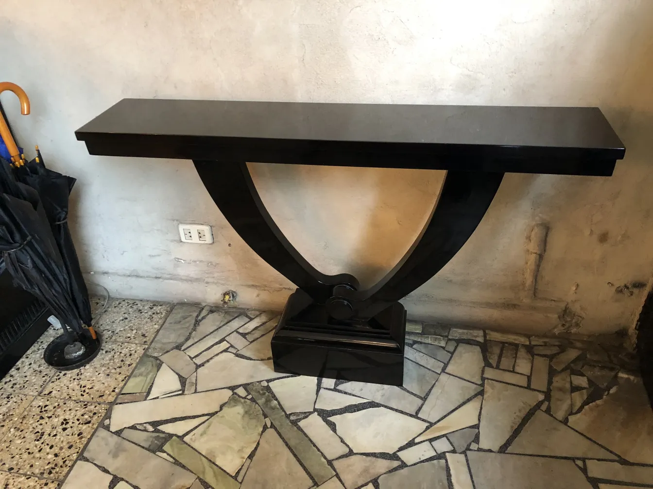 console antica a forma di V con finitura nera.