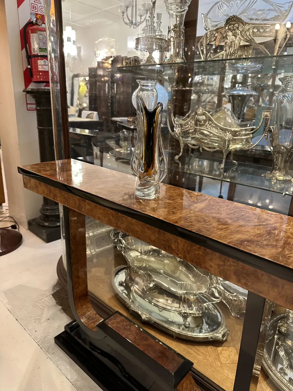 Três consoles antigos em uma mesa com detalhes decorativos