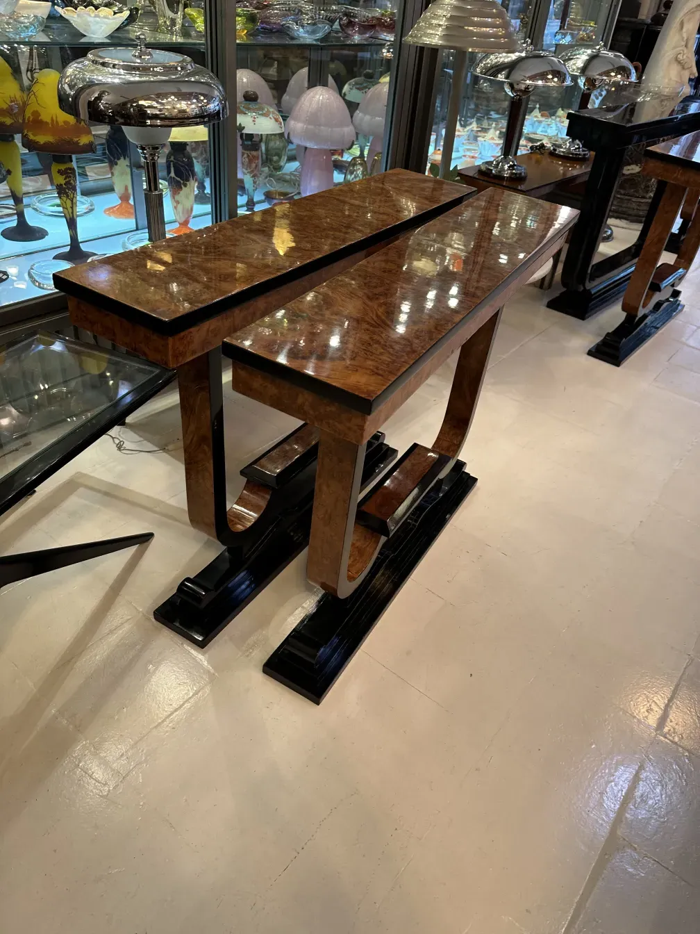 três consoles antigas com design elegante em um ambiente de antiguidades