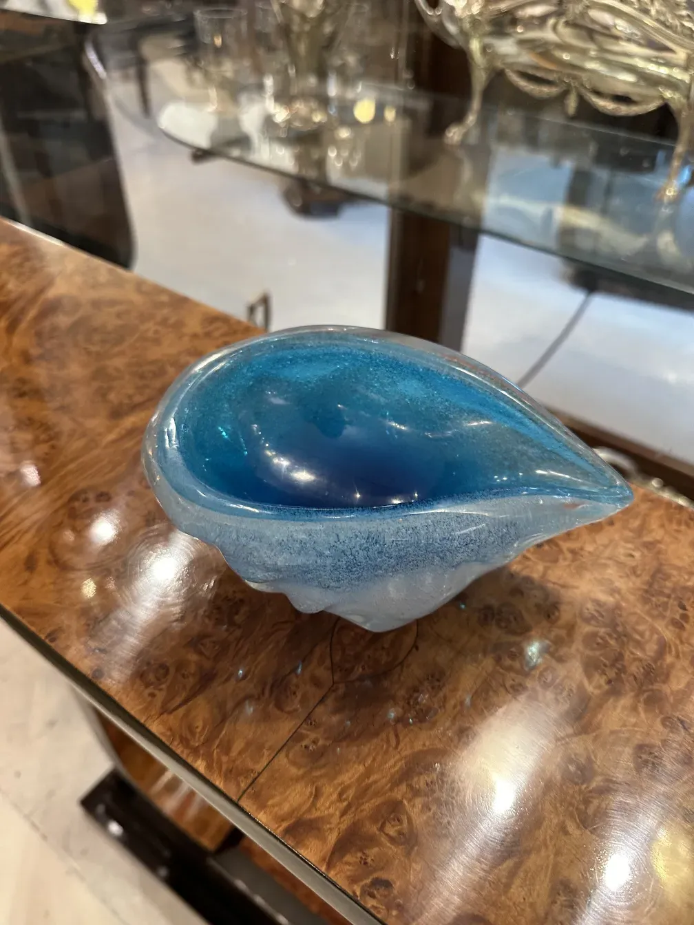 Trois dresuars antiques au design élégant et en bleu sur une table en bois.